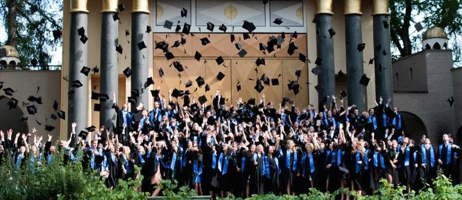 Large graduation ceremony cap toss moment